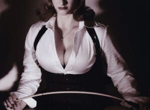 Mistress Payne in a tight white top with a whip